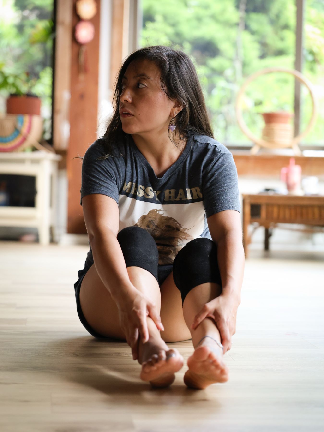 Woman stretching on the floor beside her dog